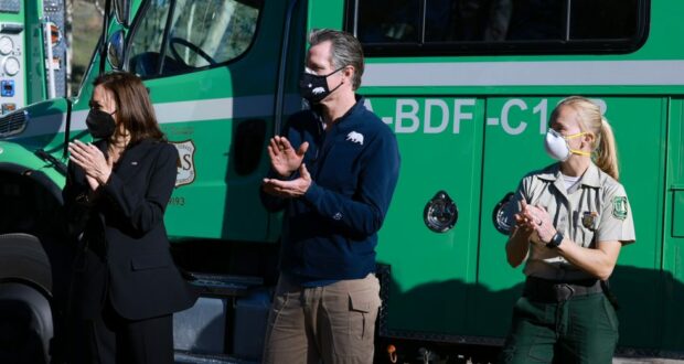 Governor Gavin Newsom and Vice President Kamala Harris clap during a trip to the San Bernardino National Forest discussing the $600 million in federal funding.