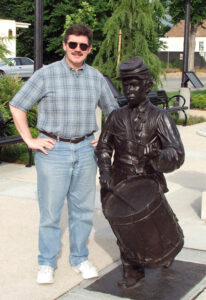 Mark Henn stands next to his statue of Willie Johnston