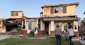 Palos Family stand outside their destroyed home.