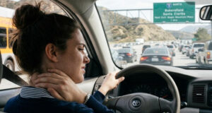A Santa Clarita commuter rubbing her stiff neck while stuck in traffic on the 5 freeway.